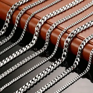 Close-up detail of silver Cuban link chains in varying widths on leather background.