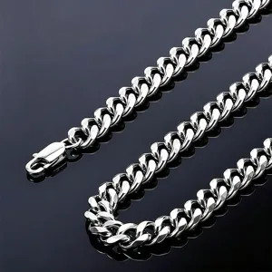 Close-up of polished silver Cuban link chain with lobster clasp detail.