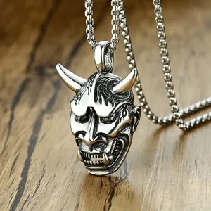 Detail view of a vintage silver Hannya mask pendant on a sturdy box chain.