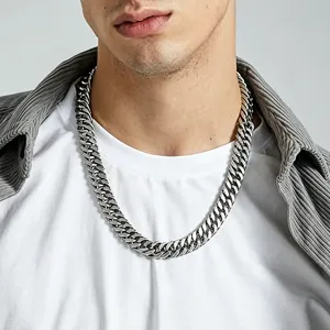 Detailed view of a thick silver stainless steel Cuban link chain necklace worn by a male model