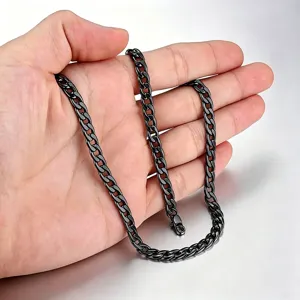 Vue détaillée d'un collier chaîne gourmette cubaine en acier inoxydable noir dans une main