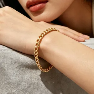 Detail view of a luxurious gold plated stainless steel Cuban link bracelet on a wrist