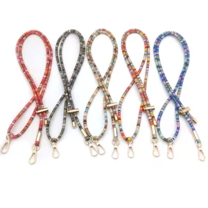 Detailed view of five colorful retro beaded phone lanyards with gold metal clasps.
