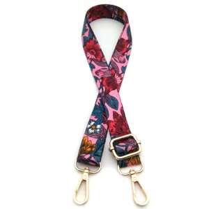 Detalle de la correa de hombro con estampado floral colorido y ganchos dorados