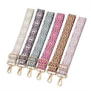 Vista dettagliata di varie tracolle per borse in jacquard con ganci dorati