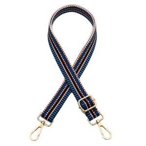 Détail d'une bandoulière étroite réglable avec motif à rayures bleues et dorées