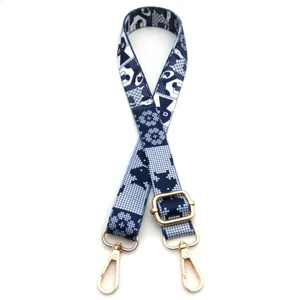 Detalle de correa con estampado geométrico azul y blanco con herrajes dorados ajustables