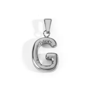 Macro view showing the texture of a silver stainless steel capital letter G pendant