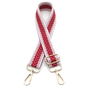 Nahaufnahme des rot-weißen Chevron-Jacquard-Taschenriemens mit goldener Hardware