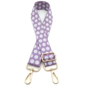 Dettaglio della tracolla regolabile viola a pois con ganci in metallo dorato per borse