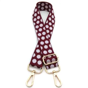 Dettaglio tracolla regolabile bordeaux a pois con accessori metallici dorati