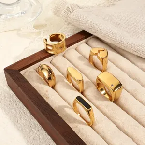 Detailed shot of various gold-plated stainless steel rings in a wooden jewelry box