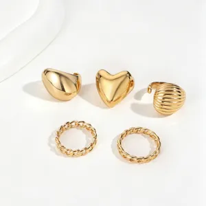 Detailed view of minimalist gold stainless steel rings with heart and chain designs