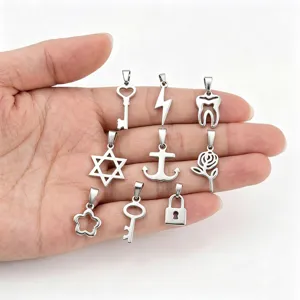 Assorted stainless steel pendants featuring key lock and anchor designs displayed on hand