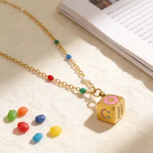 Gold stainless steel necklace with rainbow beads and a smiley face cube pendant