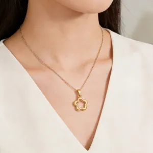 Elegant 18K gold plated stainless steel hollow flower pendant necklace on female model.