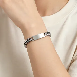 Close-up of a polished stainless steel Cuban chain ID bracelet for men on wrist