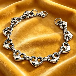 Primo piano dei dettagli del bracciale con maglie a cuore traforate in acciaio.
