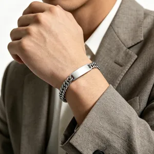 Detailed view of polished stainless steel Cuban chain bracelet on a man's wrist