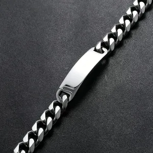 Macro di un bracciale a catena cubana in acciaio inossidabile con piastra ID lucida.