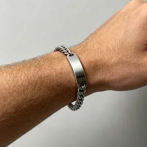 Close-up of men's stainless steel curb chain bracelet with blank DIY plate on wrist.