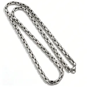 Detailed macro view of minimalist polished titanium steel tank link chain jewelry