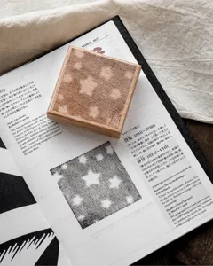 Detail of square beech wood stamp with delicate engraved star and grid pattern