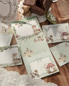 Gros plan de blocs-notes vintage avec dorure à l'or, animaux de la forêt et thématique thé.