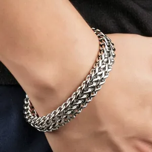 Primer plano detallado de una pulsera robusta de doble fila de acero de titanio para hombre