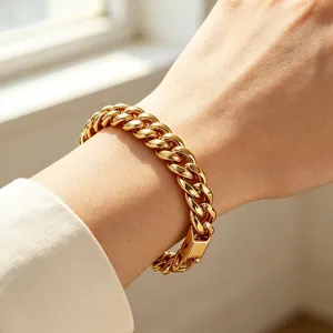 Close-up of a high-polished 18K gold-plated stainless steel Cuban link bracelet on wrist.