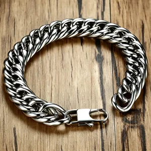 Detailed view of polished stainless steel Cuban link bracelet on a textured wood surface