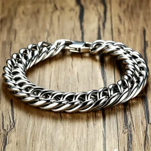 Close-up detail of heavy titanium steel Cuban chain bracelet for men on wooden background