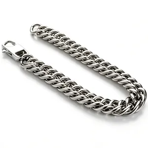 Macro detail of a high-polished silver titanium steel Cuban link chain for men.