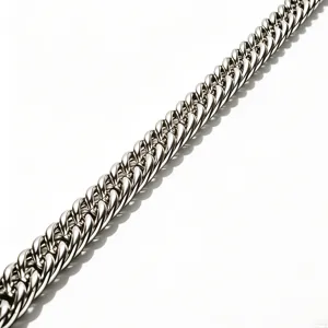 Macro view of a high-polished titanium steel Cuban link chain with glossy silver finish.
