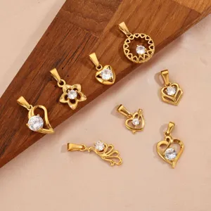 Macro view showing a collection of 18K gold-plated stainless steel Cupid and angel wing pendants