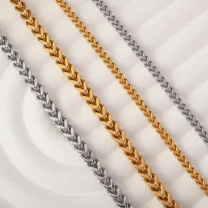 Four stainless steel wheat chains in gold and silver colors on a textured white background