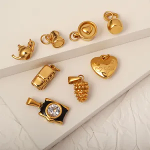 Detailed view of gold-plated stainless steel charms in heart and teapot shapes.