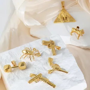 Detailed view of gold stainless steel hip-hop pendants in pistol and pyramid shapes