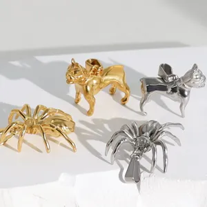 Close-up detail of hip-hop spider and bulldog animal pendants in gold and silver steel.