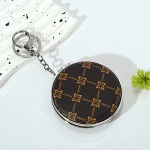 Detailed view of portable folding makeup mirror keychain with vintage floral pattern