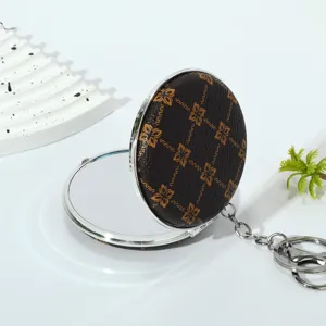 Macro detail of a portable double-sided folding makeup mirror with a floral leather cover