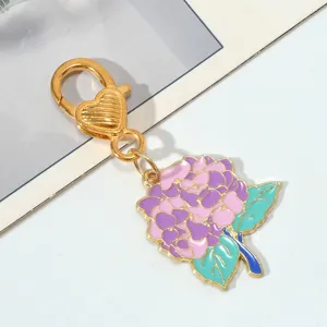 Detailed macro view of the colorful enamel hydrangea charm on a gold metal keychain