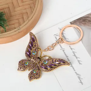 Detailed view of a sparkling purple rhinestone butterfly keychain with elegant gold alloy finish