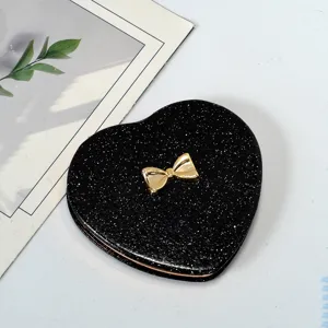 Elegant black glitter heart-shaped portable makeup mirror with a decorative gold bow