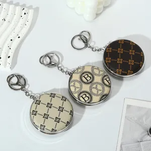 Detail showing three portable folding makeup mirrors with keychain in vintage patterns