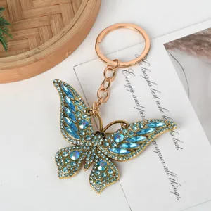 Macro detail view of an elegant butterfly keychain with sparkling blue rhinestones.