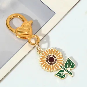Close-up view of sunflower keychain with gold heart-shaped clasp and green leaves