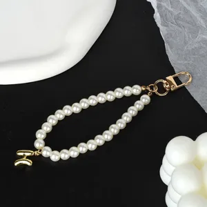 Close-up of elegant pearl keychain with gold-plated letter H charm and sturdy metal clasp