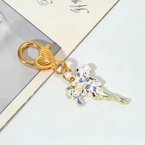 Close-up detail of a gold metal flower bouquet keychain with enamel floral pendant