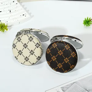Close-up detail of mini portable double-sided folding makeup mirrors with keychain chain